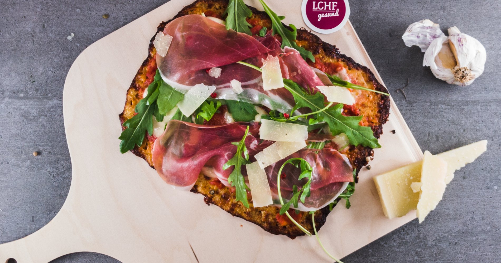 Low Carb: Rucola-Parma-Pizza - ♥ Pizzaboden lässt sich auch ohne Mehl ganz einfach selber machen! Mit Cheddar und Blumenkohl wird die Pizza fast wie das Original. - LCHF-gesund.de